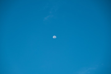 Irregular white cloud on blue sky with small the Moon in the daytime