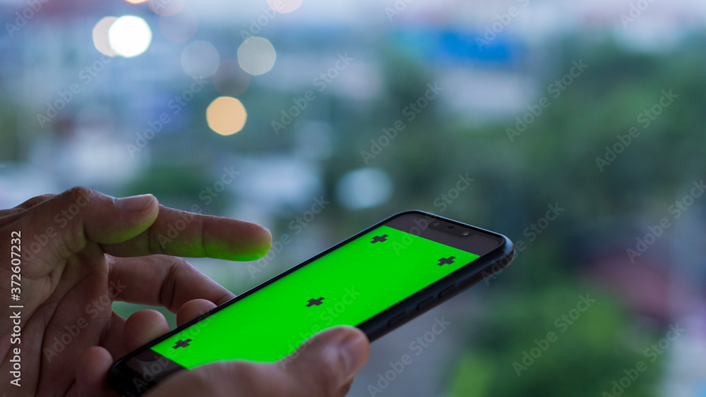 Poster the hand of a man using a smartphone with a green screen is used for editing work for various commer