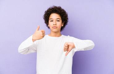 African american little boy isolated showing thumbs up and thumbs down, difficult choose concept