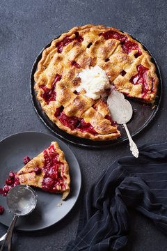Top view image of cherry pie decorated with lattice and served with ice cream