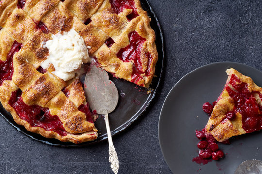 Top view image of cherry pie decorated with lattice and served with ice cream