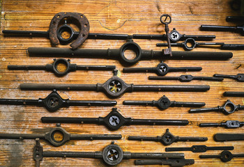 Set of different tools on wood board in studio near to a horseshoe and an iron key
