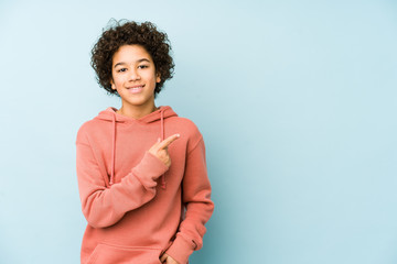 African american little boy isolated smiling and pointing aside, showing something at blank space. © Asier