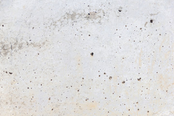 Texture of an aged and weathered grey concrete exterior wall. Plenty of holes around the surface. Conctruction and materials
