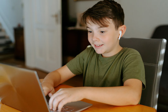 Focused kid using laptop at home