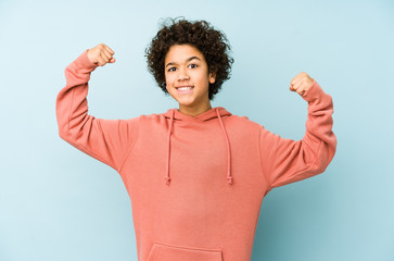African american little boy isolated showing strength gesture with arms, symbol of feminine power