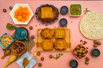 Flat lay mid autumn festival colorful food and drink on sweet pink background.