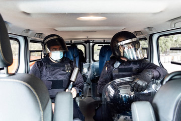 swat policeman in helmet body armor and medical mask going to operation with assault rifle