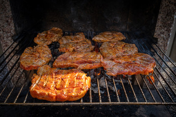 some marinated steaks on a charcoal grill on a barbecue