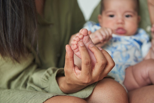 Close-up of a mother holding the feet of her Asian baby