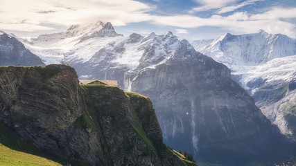Majestic view of rough mountains with uneven surface and spiky peaks partially covered with snow under bright sky at sundown