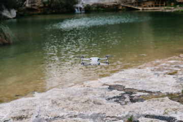 Closeup of innovative drone with propellers flying on blurred background of lake