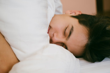 Thai boy smiling on the bed.