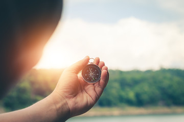 Compass of tourists on mountain at sunset sky.