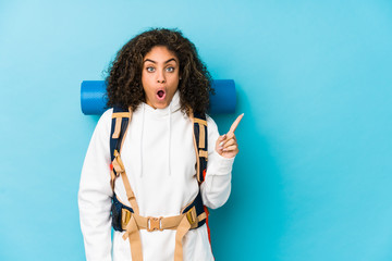 Young african american backpacker woman pointing to the side