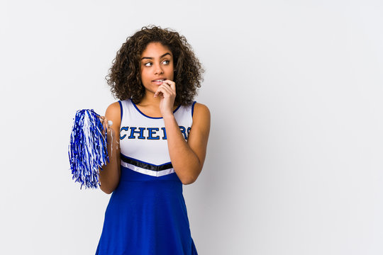 Young african american cheerleader woman isolated relaxed thinking about something looking at a copy space.