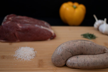 Sausages ready for cooking with raw ingredients for a grill