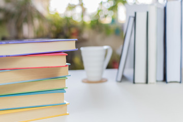 Desk with stack of study books. Textbooks for the student, university. Study from home. Distance education concept.