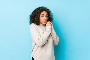 Young african american curly hair woman scared and afraid.