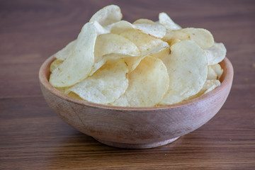 Homemade Potato Chips in bowl on wooden table
