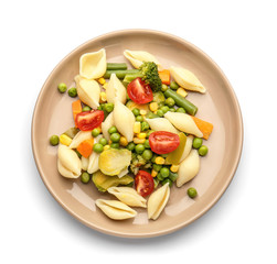 Plate with tasty conchiglie pasta and vegetables on white background