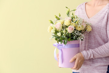 Woman with bouquet of beautiful flowers on color background