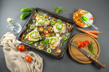 Raw chicken with ingredients for cooking on a gray background. Selective focus