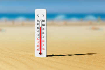 Sea coast at hot summer day. Thermometer in the sand shows plus 35 degrees celsius