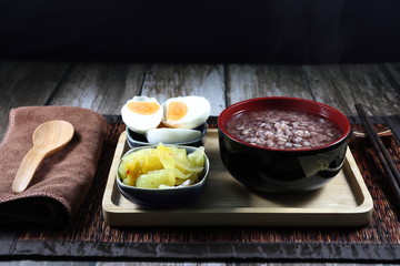 Traditional porridge set menu, boiled jasmine rice, cutting spicy pickled cabbage (Chinese lettuce) and salted egg. Famous soft food for easy digestion in Asia restaurant. 