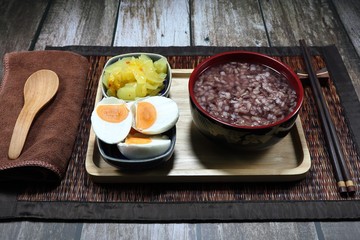Traditional porridge set menu, boiled jasmine rice, cutting spicy pickled cabbage (Chinese lettuce) and salted egg. Famous soft food for easy digestion in Asia restaurant. 