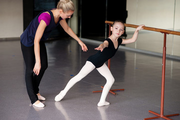 Obraz premium The coach teaches the girl how to stretch the choreography