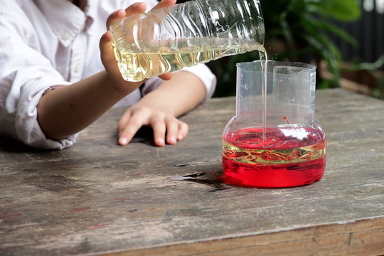 School Kid Making Oil And Water Separator Experiment At Home.Easy D.I.Y. Science Experiment.Experimenting With Oil,water And Dishwashing Detergent Is A Fun Way To Explore Basic Chemistry With Kids.