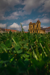 Saint George cathedral in the centre of Timisoara in Romania known also as the Dome on Plata Unirii on a warm summer day with blue skies and clouds. Grass in the foreground