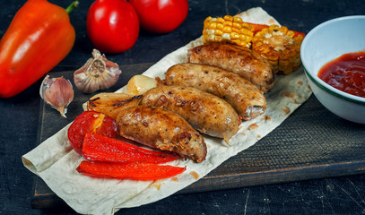 fried homemade sausages with vegetables on a plate .cooking at home . the view from the top