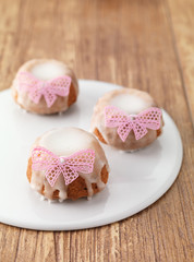 Handmade gugelhupf  cake, german and austrian cake decorated icing and pink ribbon on wooden background