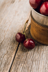 Freshly harvested cherries in vintage metal cup. Selective focus. Shallow depth of field.
