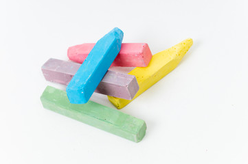 scattered colorful children's crayons on a white background close up