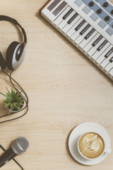piano, cup of coffee, headphone, microphone and plant on wooden floor. film look. relaxation concept