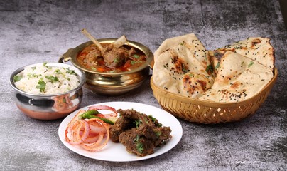Mutton curry Served with naan or bread and jeera rice over wooden background.