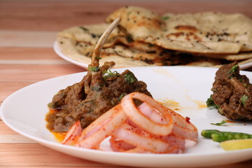 Bhuna Gosht Mutton masala OR Indian Lamb masala and mutton curry Served with naan or bread and onion over wodden background.