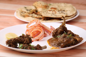 Bhuna Gosht Mutton masala OR Indian Lamb masala and mutton curry Served with naan or bread and onion over wodden background.