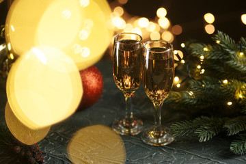 Ribbon, baubles and wine against Christmas lights.