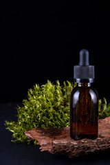 composition with glass bottle of body care organic cosmetics on tree bark pedestal with  real , mosses  Cosmetic background  mock up for product presentation.