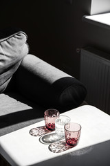Crystal red glass on white table. Hard shadows in sunlight.