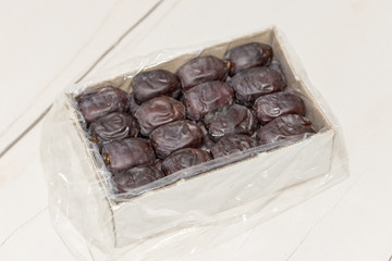 Oriental dates in a cardboard box on a white background. View from above.