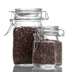 Healthy dietary chia seeds in glass jars isolated