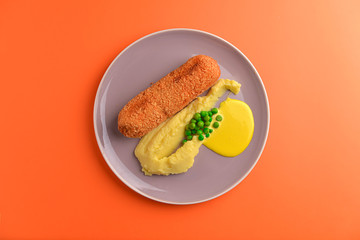 Cordon bleu cutlet, deep fried meat served with mashed potatoes and green peas on gray plate over orange background.