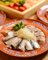 Traditional Ukrainian food herring fish, side view, horizontal. Served on a rustic wooden table.
