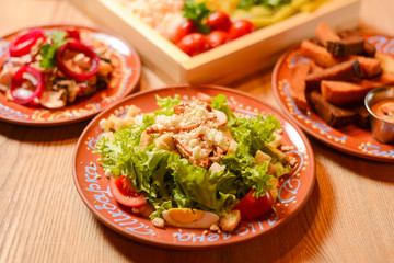 Covered table with traditional Ukrainian food, side view, horizontal. Healthy vegetable salad with croutons.