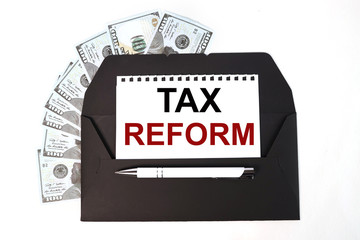 TAX REFORM. THE TEXT IS WRITTEN on white paper on a black envelope near the money bills